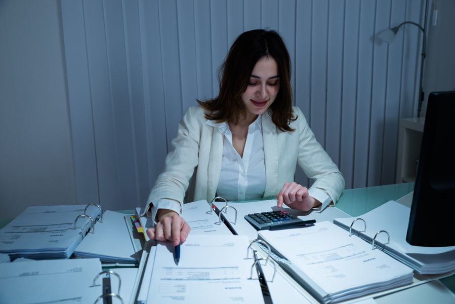 A woman looks calm with papers on a desk. Saving Money on Your Business’s HVAC System.