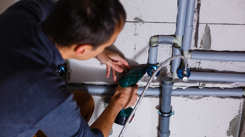 Plumber makes wiring of sewer pipes.